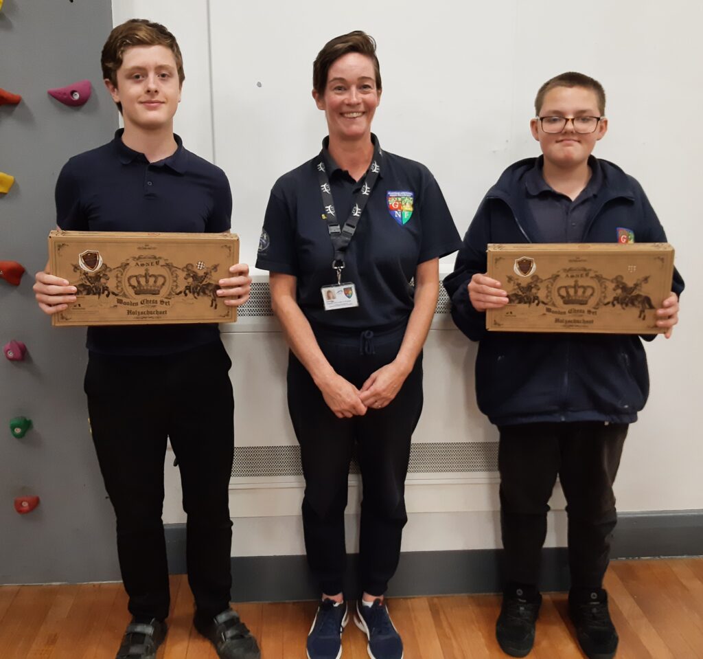 2 Ambergate Pupils with their teacher and their winning prize of a chess board.